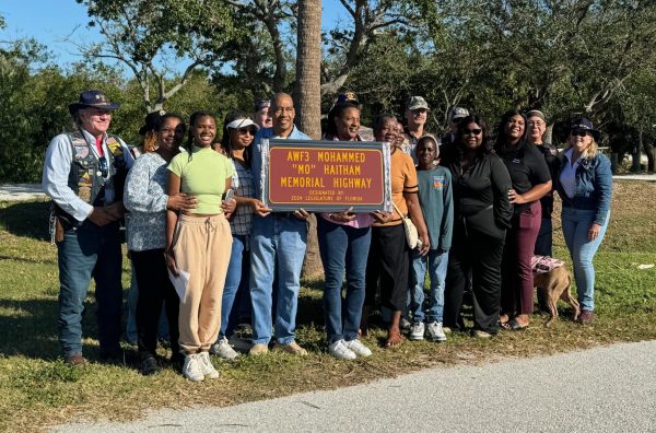 Family and friends of Mohammed “Mo” Haitham hold the maker that was placed on the road.